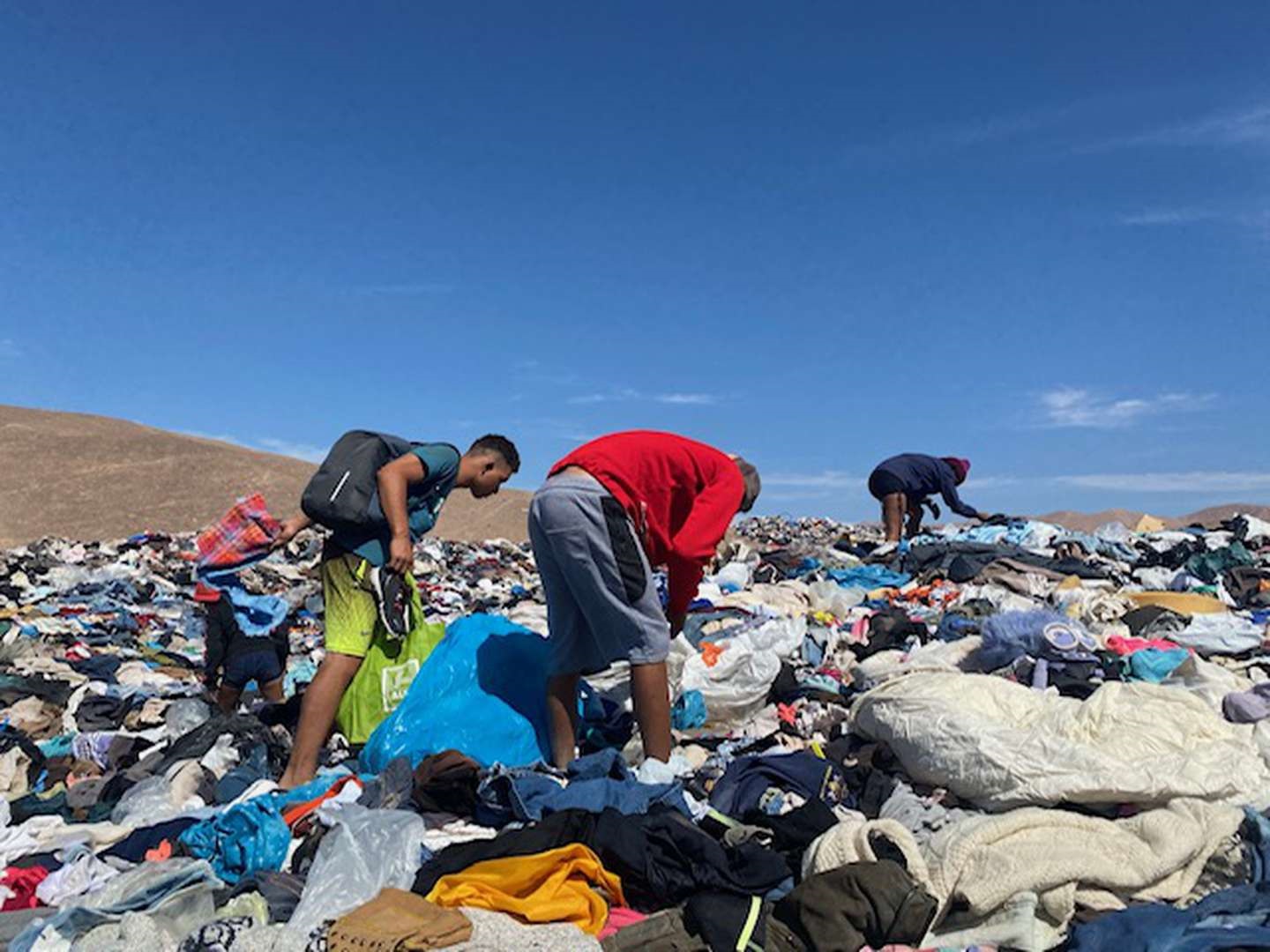 Migrantes buscando ropa en el basural