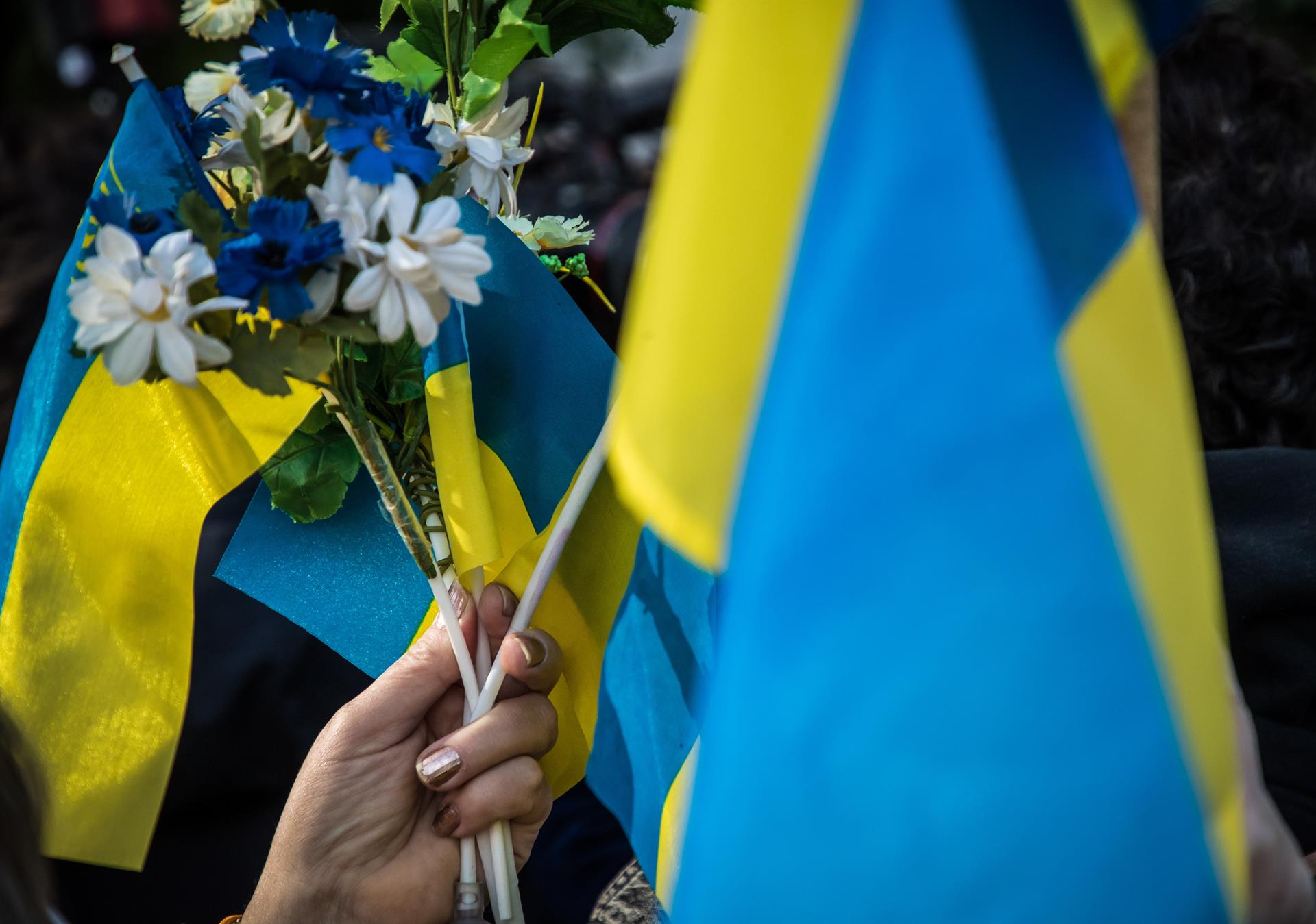 Persona sostiene bandera de Ucrania. Foto: EFE/CHRISTOPHE PETIT TESSON