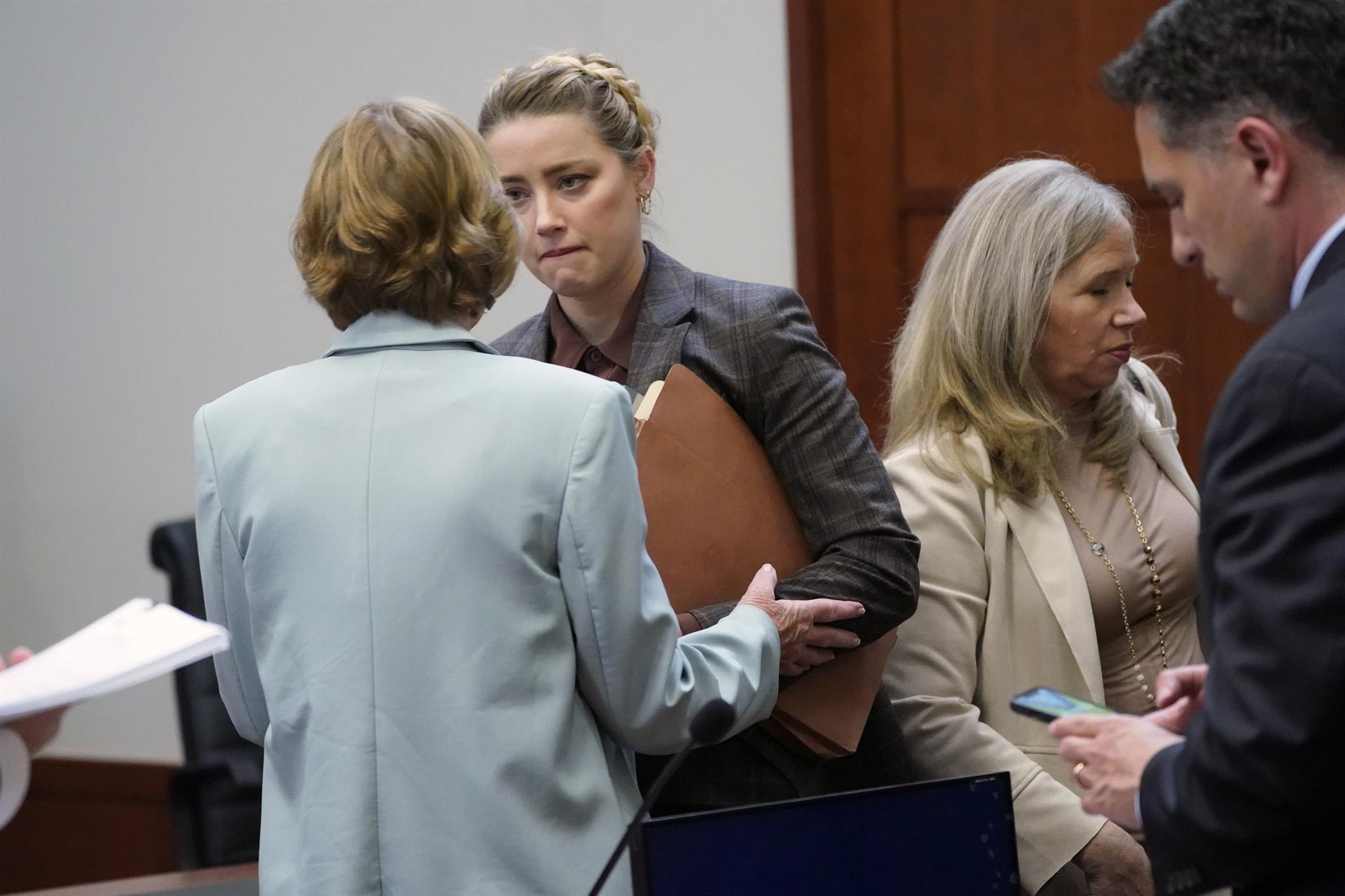 Fairfax (Estados Unidos), 02/05/2022.- La actriz estadounidense Amber Heard (2-L) habla con su abogado al final del día en la sala del Tribunal de Circuito del Condado de Fairfax en Fairfax, Virginia, Estados Unidos, 02 de mayo de 2022. El actor estadounidense Johnny Depp demandó a su exesposa la actriz estadounidense Amber Heard por difamación en el Tribunal de Circuito del Condado de Fairfax después de que ella escribiera un artículo de opinión en The Washington Post en 2018 en el que se refería a sí misma como una "figura pública que representa el abuso doméstico". (Estados Unidos) EFE/EPA/STEVE HELBER / POOL