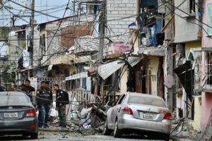 Miembros de la Policía Nacional inspeccionan el lugar de una explosión, que el gobierno ecuatoriano atribuye al crimen organizado, en el sur de Guayaquil, Ecuador, el 14 de agosto de 2022. Foto: AFP.
