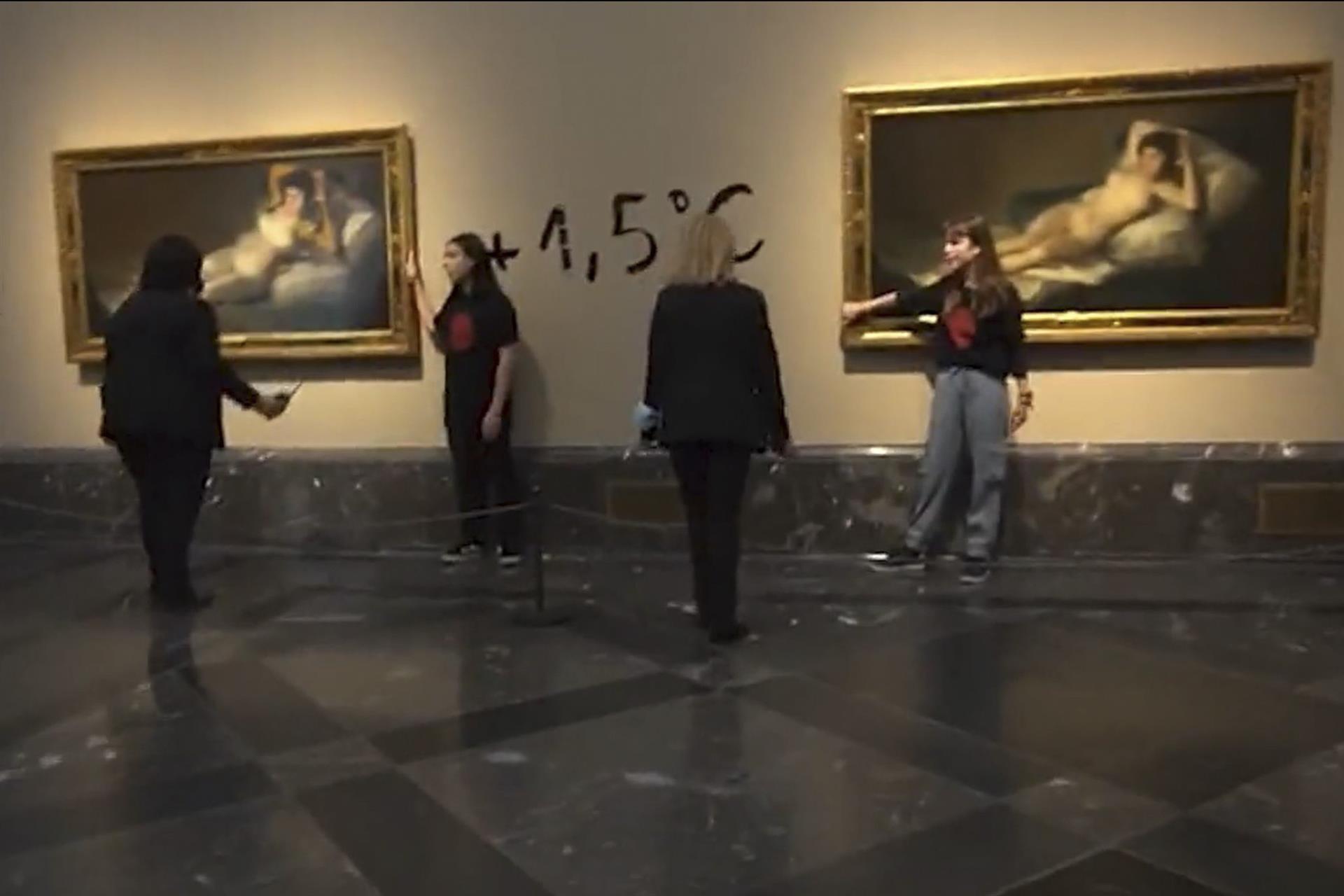 MADRID, 05/11/2022.- Captura de video del momento en el que dos activistas de la organización Futuro Vegetal se han pegado a los marcos de los cuadros de "La maja vestida" y "La maja desnuda" del Museo del Prado y han escrito en la pared '+1.5°' en referencia al anuncio de la ONU de la imposibilidad de cumplimiento del Acuerdo de París. EFE/Futuro Vegetal.