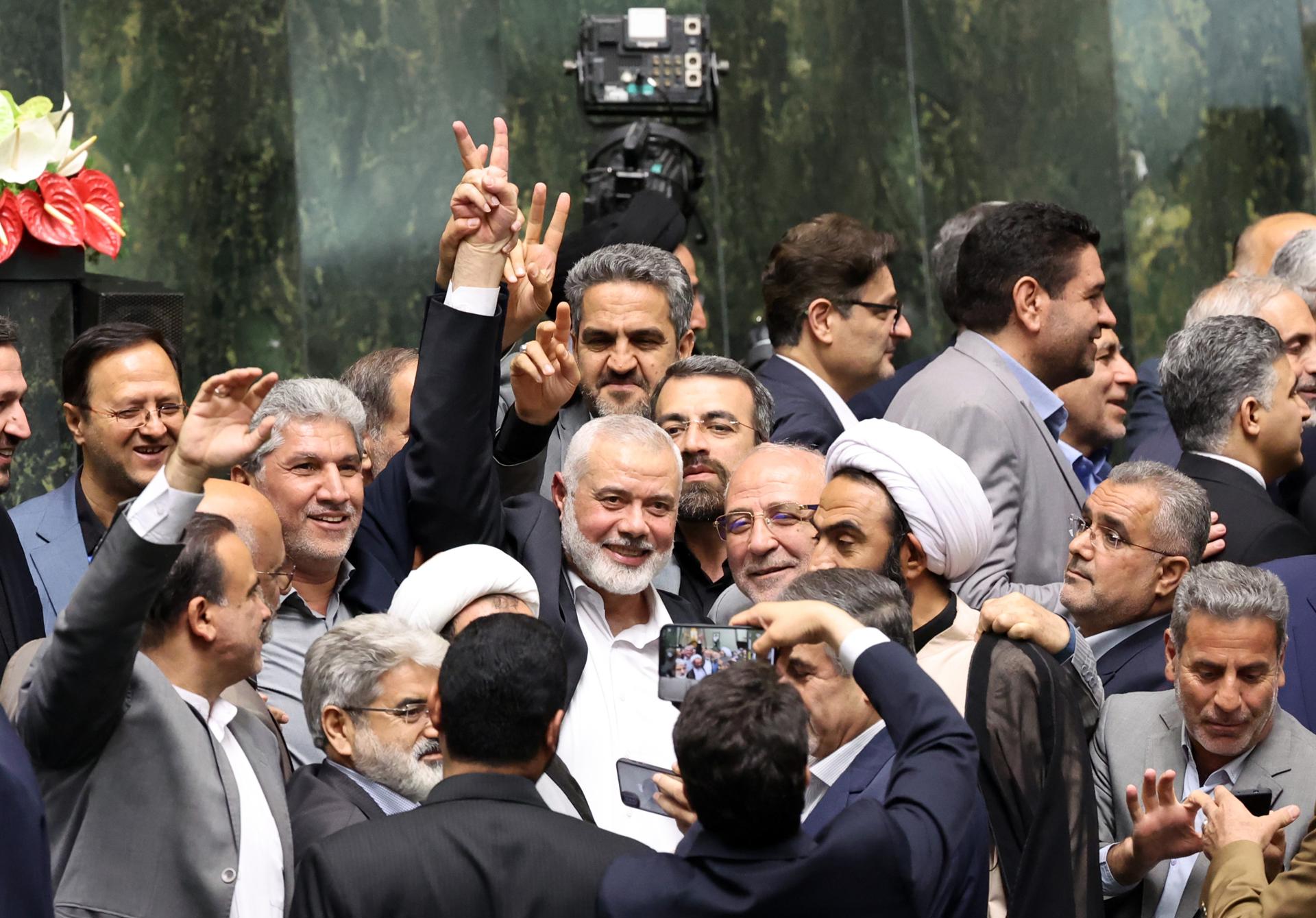 Hamas political leader Ismail Haniyeh (C) flashes victory sign as surrounded by Iranian lawmakers at the Iranian parliament in Tehran, Iran, 30 July 2024 (issued 31 July 2024). According to an Iranian Revolutionary Guard Corps (IRGC) statement on 31 July 2024, Haniyeh and one of his bodyguards were targeted and killed in Tehran on 31 July 2024. (Teherán) EFE/EPA/ABEDIN TAHERKENAREH